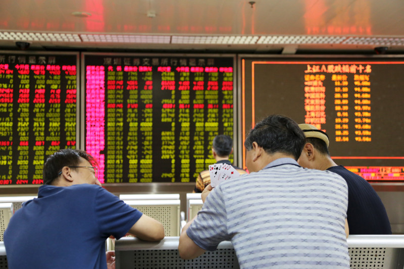 Investors play cards in front of an electronic board showing stock information at a brokerage house in Beijing, August 17, 2015. u00c2u008fu00e2u20acu201d Reuters pic