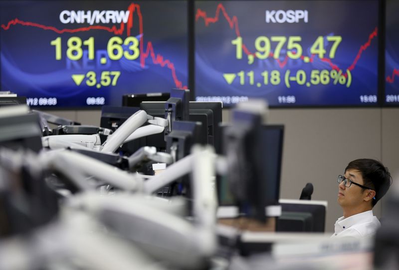 A currency dealer works in front of electronic boards showing the Korea Composite Stock Price Index (right) and the exchange rate between the Chinese yuan and South Korean won, in Seoul, August 12, 2015. u00e2u20acu201d Reuters pic
