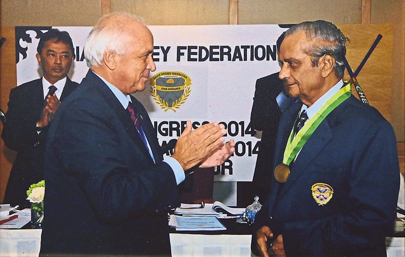 FIH president Leandro Negre applauds after awarding Alagendra long serving appreciation award for his contribution to hockey. 