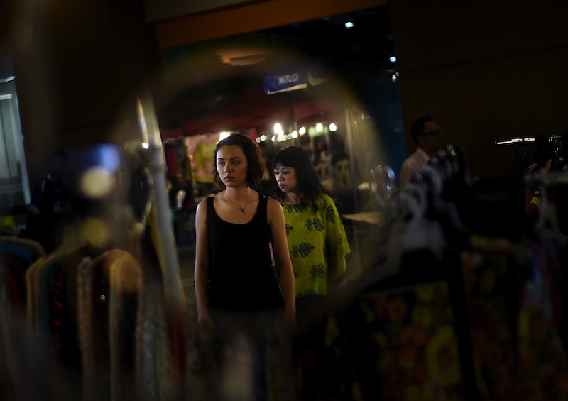 Shoppers are reflected in a mirror at a weekly market in Kuala Lumpur on March 19, 2015. u00e2u20acu201du00c2u00a0AFP pic