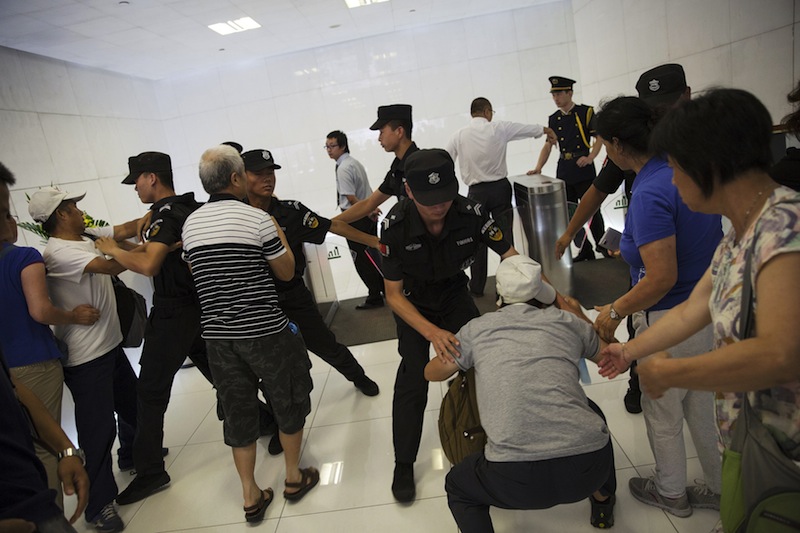 Relatives of passengers who were onboard missing Malaysia Airlines flight MH370 are stopped by policemen as they try to enter the building where the Malaysia Airlines office is located, in Beijing August 5, 2015.u00c2u00a0u00e2u20acu201d Reuters pic