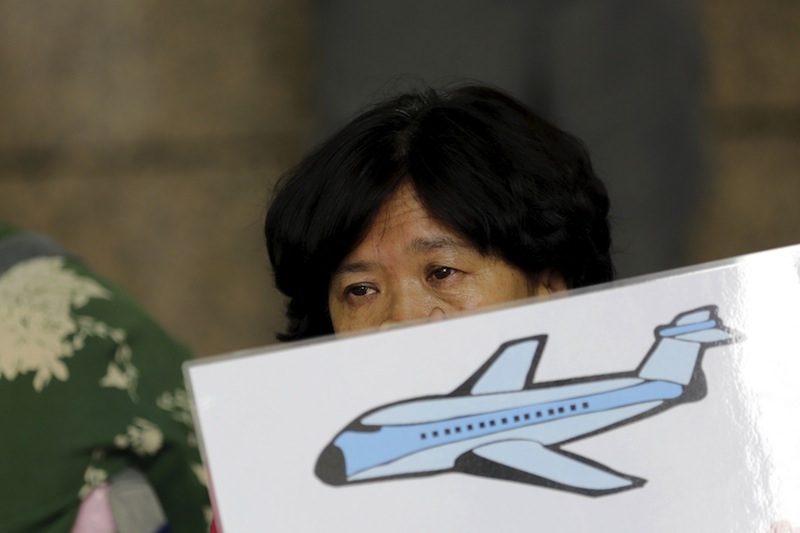 A woman whose relative was aboard Malaysian Airlines flight MH370 holds a placard as she and other family members express their demands to Malaysia Airlines outside its Beijing office August 6, 2015.u00c2u00a0u00e2u20acu201d Reuters pic