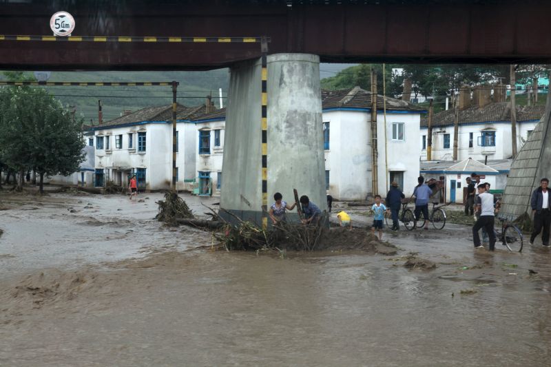 Residents attempt to clear flood debris from under a bridge in the city of Rajin in North Korea. u00e2u20acu201d Reuters pic