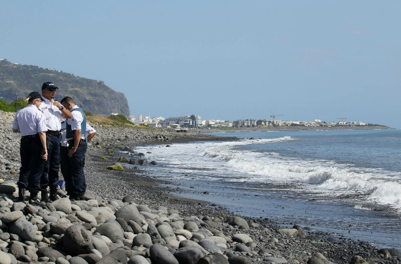 Police officers inspect metallic debris found on a beach in Saint-Denis on the French Reunion Island in the Indian Ocean on August 2, 2015, close to where a Boeing 777 wing part believed to belong to missing flight MH370 washed up last week. u00e2u20acu201d AFP pic