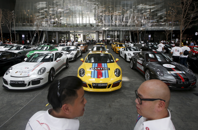 Members of the local Porsche motoring club chat after parking their convoy of 50 cars during an event at an office building in Singapore's central business district July 24, 2015. u00e2u20acu201d Reuters pic