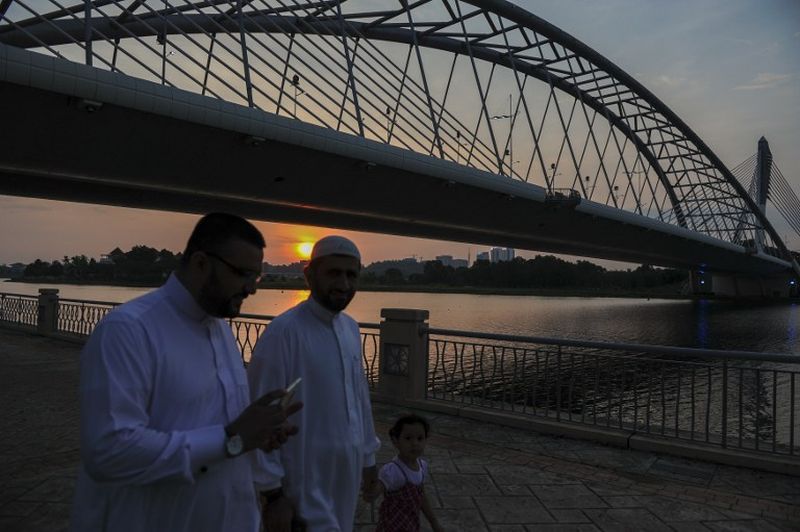 Tourists from the Middle East walk under the Seri Saujana Bridge during sunset in Putrajaya on August 15, 2015. u00e2u20acu2022 AFP pic