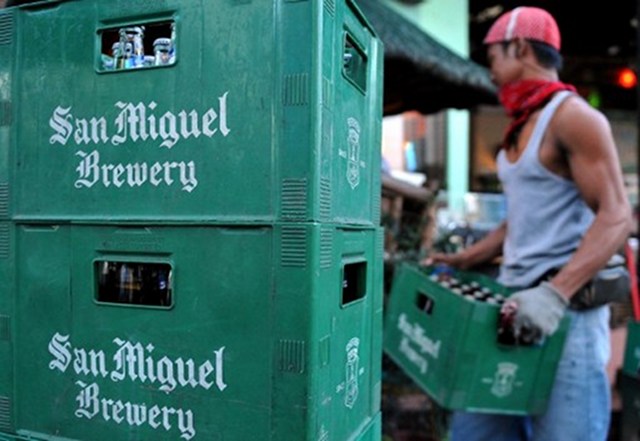 A San Miguel Corporation delivery man lifts a crate filled with beer bottles in Manila. u00e2u20acu201d AFP pic