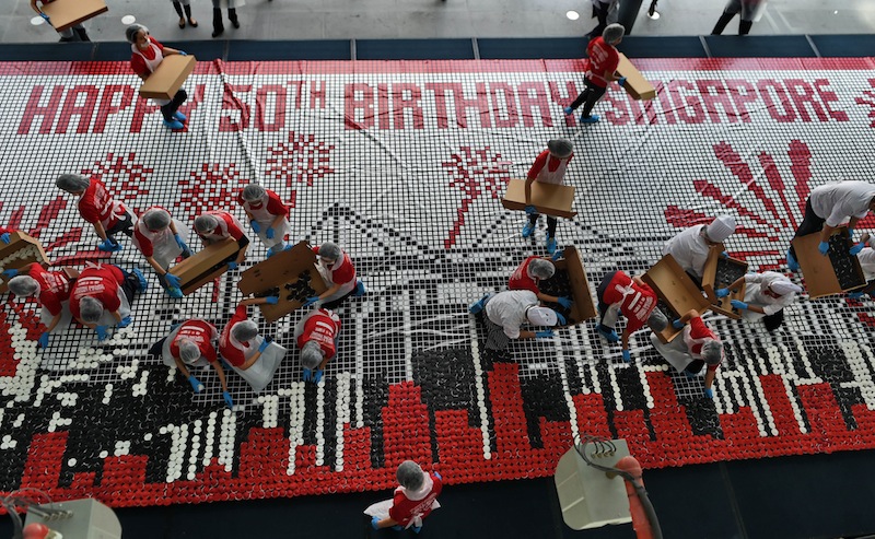Volunteers arrange cupcakes mosaic image to celebrate upcoming 50th National Day celebration in Singapore. u00e2u20acu201d AFP pic