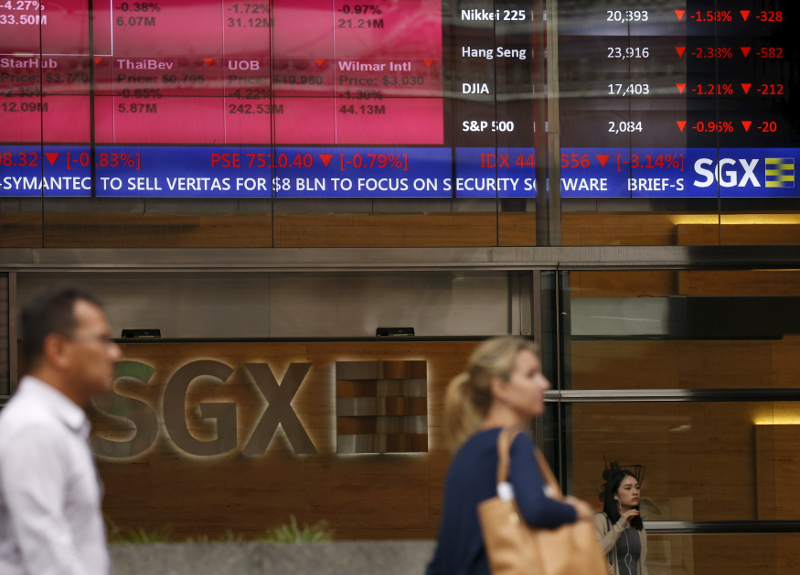 People pass a stock board showing stocks in red outside the Singapore Exchange in the central business district in Singapore August 12, 2015. u00e2u20acu201d Reuters pic