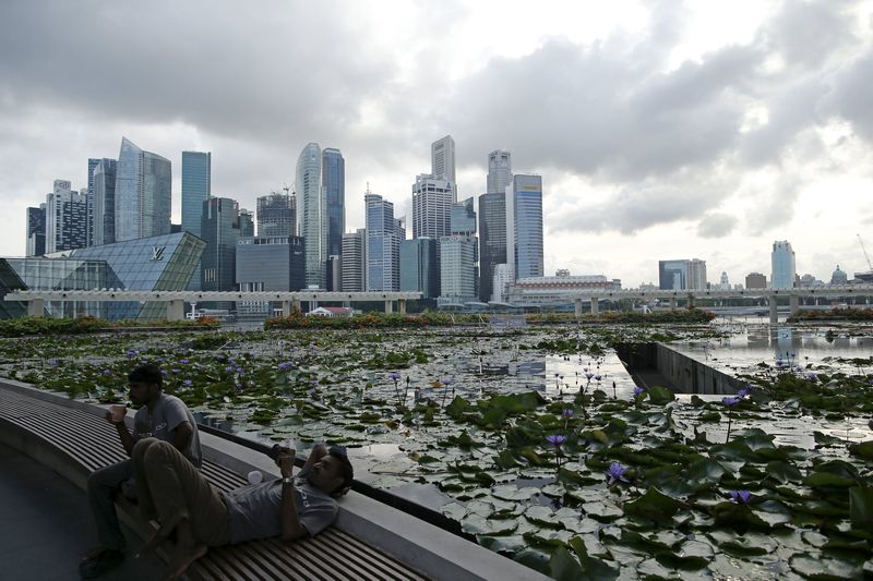 Labourers take a break at the end of the work day against the backdrop of the financial district of Singapore. The island republic's GDP is likely to have contracted in the second quarter. u00e2u20acu201d Reuters pic
