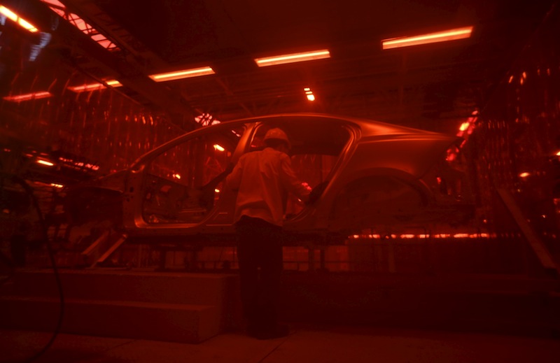 A man works at an assembly line of the new Volvo automobile manufacturing plant in Chengdu, Sichuan province, in this June 5, 2013 file photo.u00c2u00a0u00e2u20acu201d Reuters pic