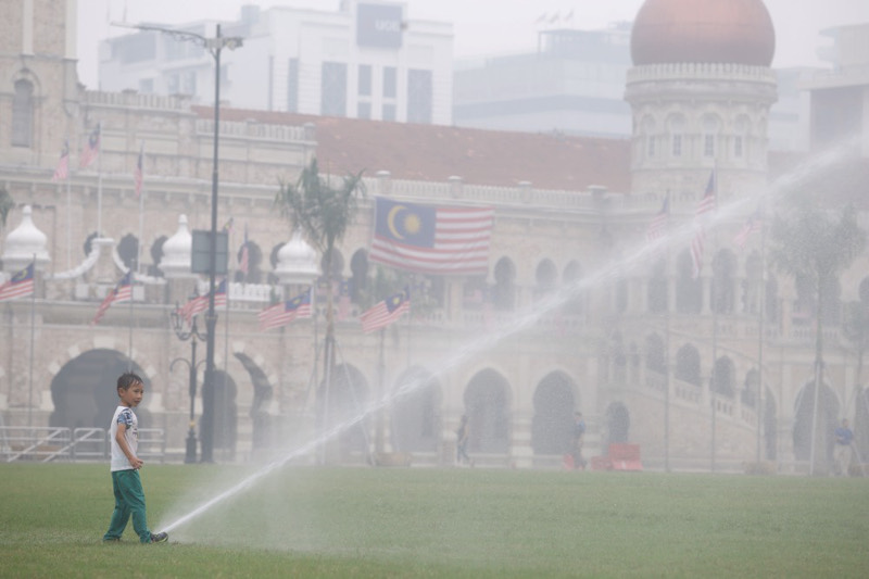 A boy playing with the water-sprinkler on the lawn at Dataran Merdeka, Kuala Lumpur, September 14, 2015. u00e2u20acu201d Picture by Choo Choy May