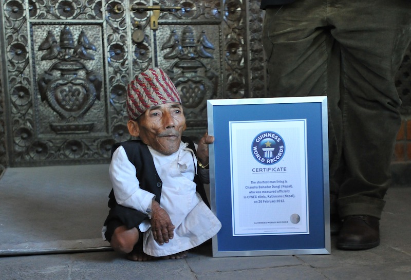 A file photo taken on February 26, 2012 shows Chandra Bahadur Dangi, from Nepal, as he is presented with a certificate by a Guinness World Records official in Kathmandu. u00e2u20acu201d AFP pic