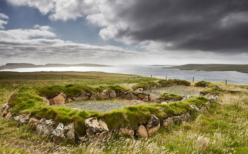 The low grass-carpeted walls of a Viking longhouse site, overlooking the Balta Sound, in Hamar, Scotland, September 2015. — Andy Haslam/The New York Times pic
