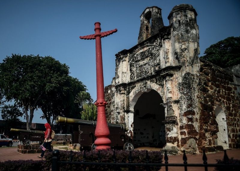 A woman walks past the remains of the 16th century Portuguese A'Famosa fort in the historical city of Malacca, September 5, 2015. u00e2u20acu2022 AFP pic