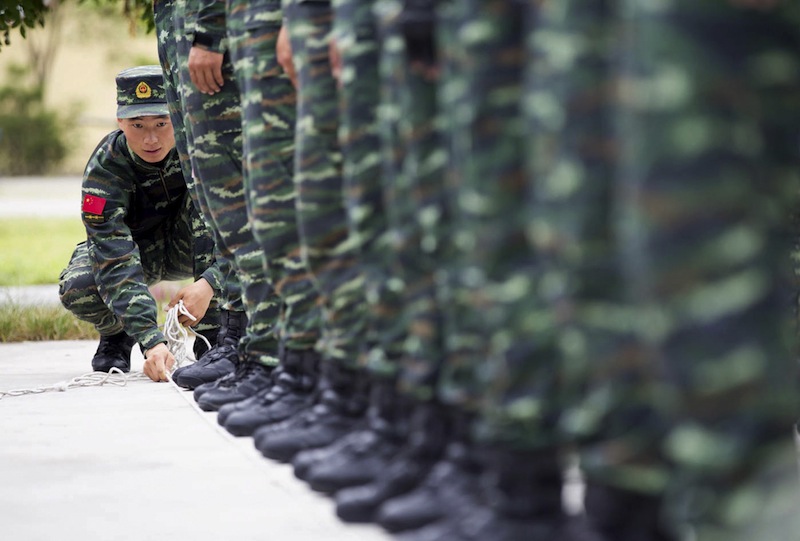 A soldier of China's People's Liberation Army uses a rope to line up other soldiers during a training session for a military parade to mark the 70th anniversary of the end of World War Two, at a military base in Beijing, China, September 1, 2015.u00c2u00a0u00e2u20acu201d Reu