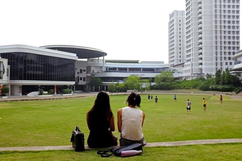 Young voter Diyana (left) who works in the finance industry, and a friend sit at the Town Green at the National University of Singaporeu00e2u20acu2122s University Town.u00c2u00a0_ TODAY pic