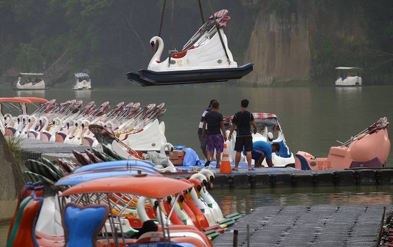 A tourist boat is lifted into the air to be secured in Pitan, a popular area in Xindian district in New Taipei City on September 27, 2015 as typhoon Dujuan approaches the northeast of Taiwan. u00e2u20acu201d AFP pic