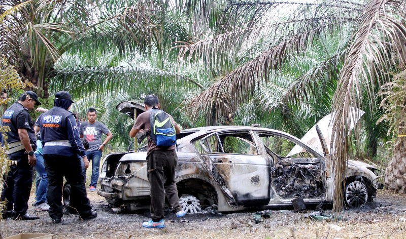A police forensic team checking the car believed to belong to Anthony Kevin Morais, that was found burned in an oil palm plantation in Kampung Sungai Samak on Sept 6, 2015. u00e2u20acu201d Bernama pic