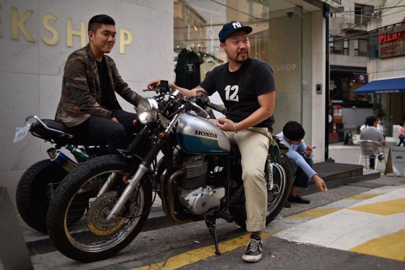 In a photo taken on August 29, 2015 two men sit on motorcycles in the upmarket Garuso-gil area of Gangnam, in Seoul. — AFP pic