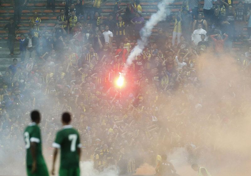 Players from Saudi Arabia watch as a flare is thrown during their 2018 World Cup qualifying match against Malaysia in Kuala Lumpur, September 8, 2015. u00e2u20acu201d Reuters pic