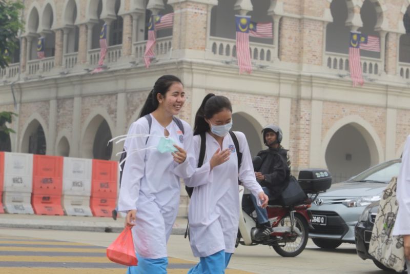 Schoolgirls crossing the road near Dataran Merdeka in the worsening haze, September 14, 2015. u00e2u20acu201d Picture by Choo Choy May