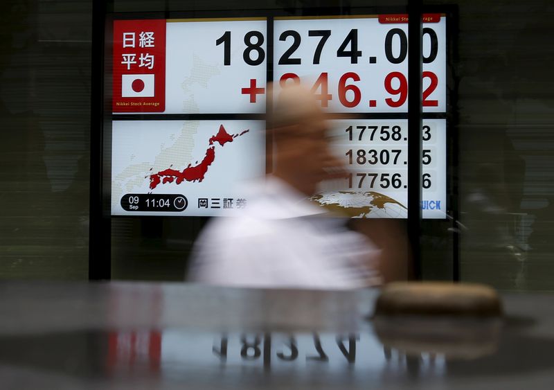 A pedestrian walks past electronic boards showing the Japan's Nikkei average outside a brokerage in Tokyo, September 9, 2015. u00e2u20acu201d Reuters pic