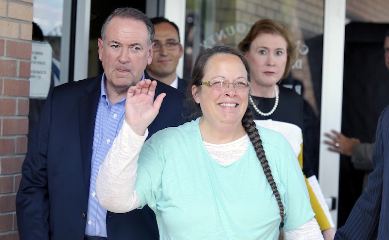 Kim Davis, flanked by Republic presidential candidate Mike Huckabee (left) waves as she walks out of jail in Grayson, Kentucky September 8, 2015. u00e2u20acu201d Reuters pic