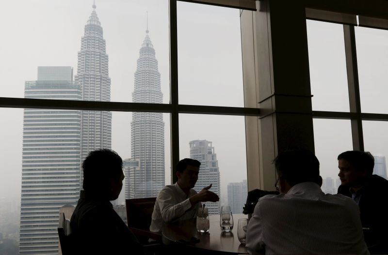 Office workers have lunch in front of the Petronas Towers shrouded by haze in Kuala Lumpur, Malaysia. Picture released September 8, 2015. u00e2u20acu2022 Reuters pic