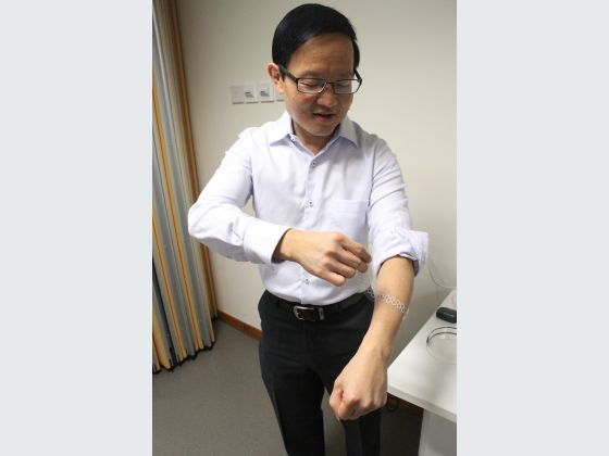 Professor Lim showing how one of their liquid-based tactile sensors can be worn.
