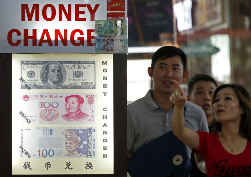 People look at the exchange rate at a moneychanger displaying a poster of US dollar bill, Chinese yuan and Malaysian ringgit in Singapore August 24, 2015.  u00e2u20acu201d Reuters pic 
