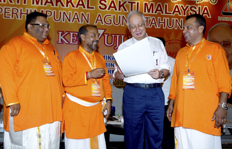 Prime Minister Datuk Seri Najib Razak (second right) examines the memorandum he receives from Makkal Sakti Party president Datuk RS Thanenthiran (left) during the opening of the partyu00e2u20acu2122s annual general assembly, Sept. 13, 2015. u00e2u20acu201d Bernama pic