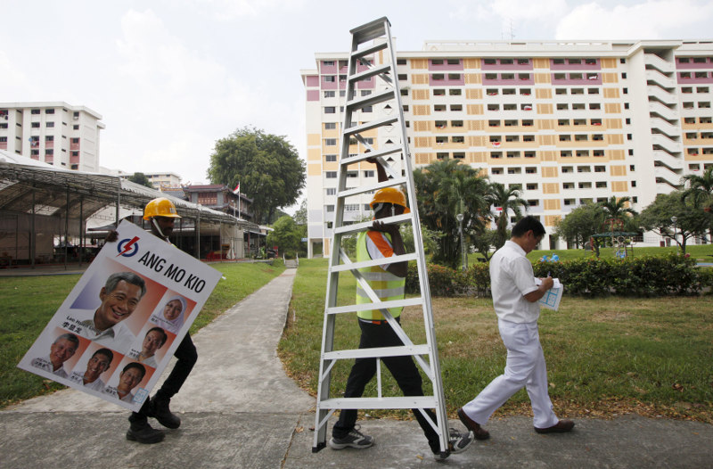Workers prepare to put up a Peopleu00e2u20acu2122s Action Party (PAP) sign on a street lamp ahead of the general election in Singapore September 1, 2015. u00e2u20acu201d Reuters pic