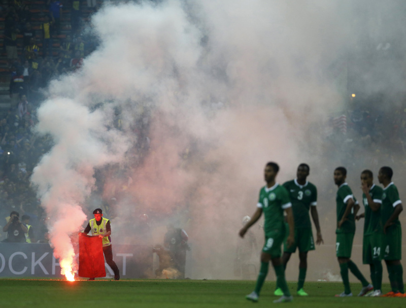 A police officer extinguishes a flare on the pitch during the 2018 World Cup qualifying match between Malaysia and Saudi Arabia in Kuala Lumpur, September 8, 2015. u00e2u20acu201d Reuters pic