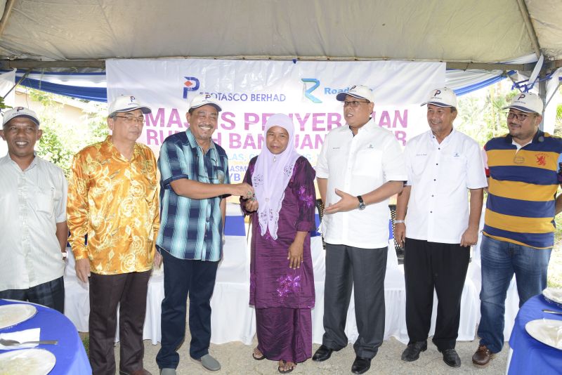 Single mum, Puan Ruzaini bt Abdullah receiving the key to her new house, presented by Galas ADUN, YB Ab Aziz Yusoff and Roadcare (M) Sdn Bhd.