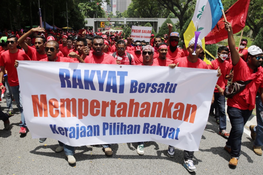 A group of red shirt protesters hold a sign as they walk into Padang Merbok in Kuala Lumpur, September 16, 2015.u00c2u00a0u00e2u20acu201d Picture by Choo Choo May