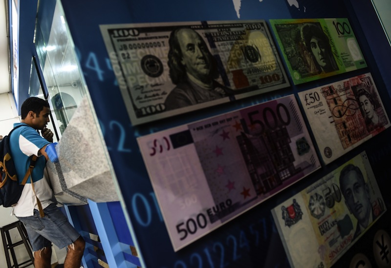 A foreign tourist inquires about exchange rates on the Malaysian ringgit at a foreign currency money-changer in Kuala Lumpur on August 24, 2015. u00e2u20acu201d AFP pic