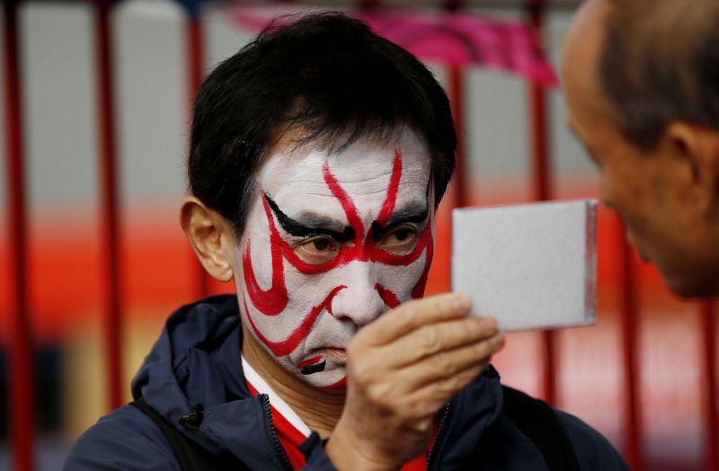 A Japan fan has his face painted outside the ground in Kingsholm.