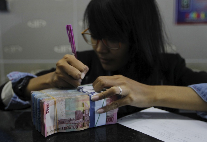 A money changer prepares Indonesian rupiah for a customer in Jakarta, Indonesia, September 1, 2015.u00c2u00a0u00e2u20acu201d Reuters pic