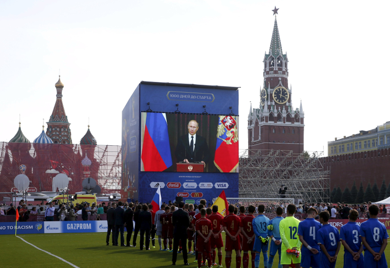 Officials, participants an under-16 tournament and spectators listen to Russia's President Vladimir Putin delivering a speech via a video link from Sochi in central Moscow, Russia, September 18, 2015.