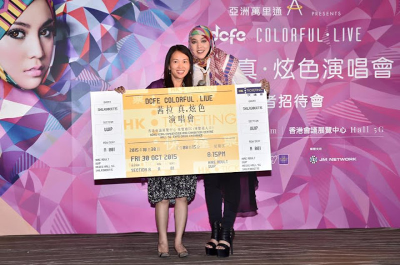 Shila Amzah and a representative from DCFE poses with a ticket to her Hong Kong concert in this photo taken from her official Facebook page.