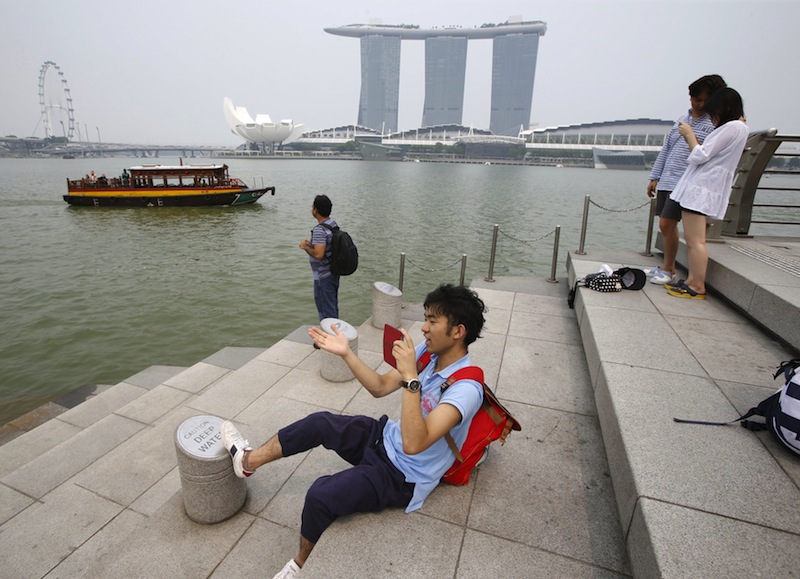 Tourists take photos at the Merlion Park shrouded by a slight haze near the central business district in Singapore September 7, 2015. u00e2u20acu201d Reuters pic
