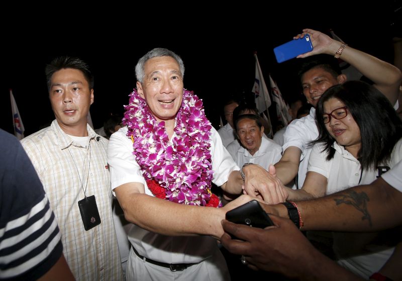 Singapore Prime Minister, Secretary-General Peopleu00e2u20acu2122s Action Party Lee Hsien Loong (C) celebrates with supporters after general election results at a stadium in Singapore September 12, 2015. REUTERS/Edgar Su