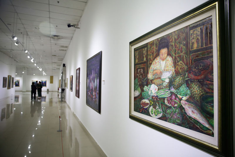 Scenes of traditional Peranakan life, such as Nyonyas preparing food in the kitchen, are a feature of Lee Goh’s works.