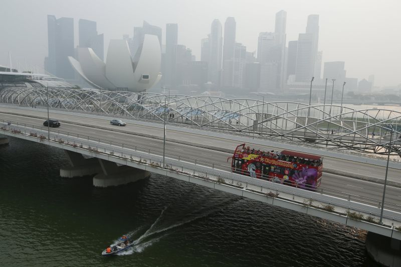 A tourist bus passes the skyline of the central business district shrouded by haze in Singapore September 29, 2015. u00e2u20acu201d Reuters pic