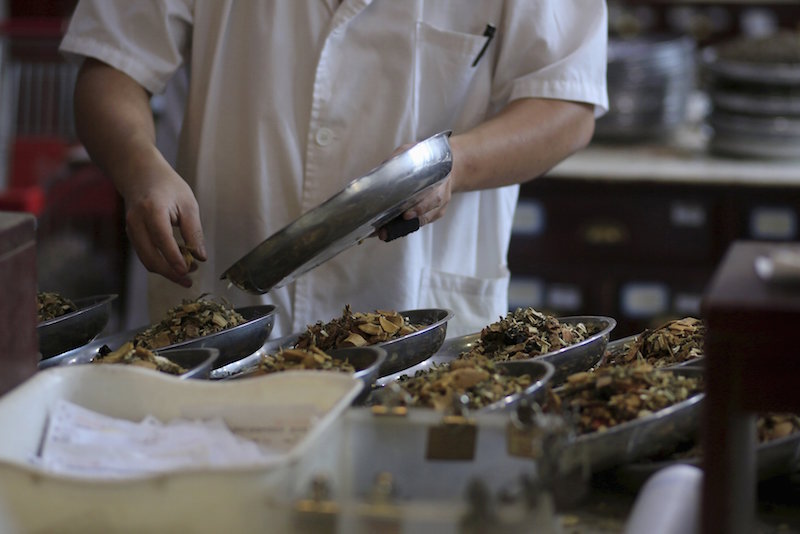An employee works at a traditional Chinese medicine shop in Shanghai September 16, 2015. u00e2u20acu201d Reuters pic