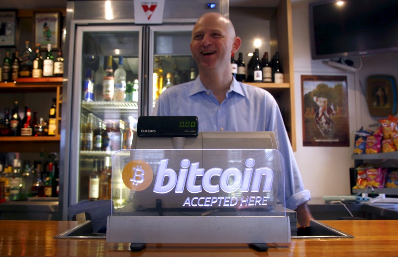 Publican Grant Fairweather talks with a customer from behind the bar where a bitcoin sign is displayed in Sydney, Australia, September 29, 2015. u00e2u20acu201d Reuters pic