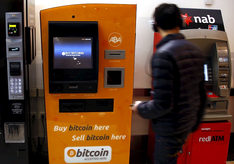 A customer of an Australian bank withdraws money from an Automatic Teller Machine (ATM) next to a Bitcoin ATM at a shopping mall in central Sydney, Australia, in this picture released on October 4, 2015. u00e2u20acu201d Reuters pic