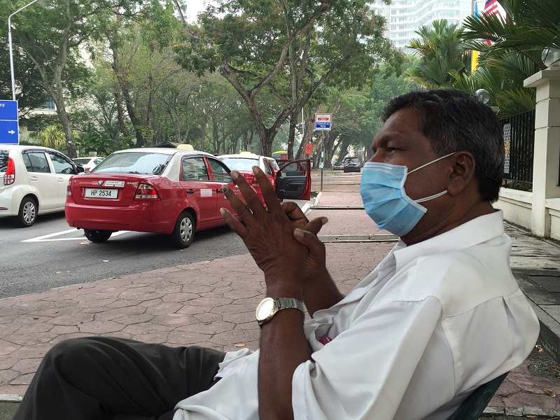 A taxi driver is seen wearing a face mask while waiting for passengers on a hazy morning in Penang, on October 3, 2015. u00e2u20acu201d Picture by K.E. Ooi
