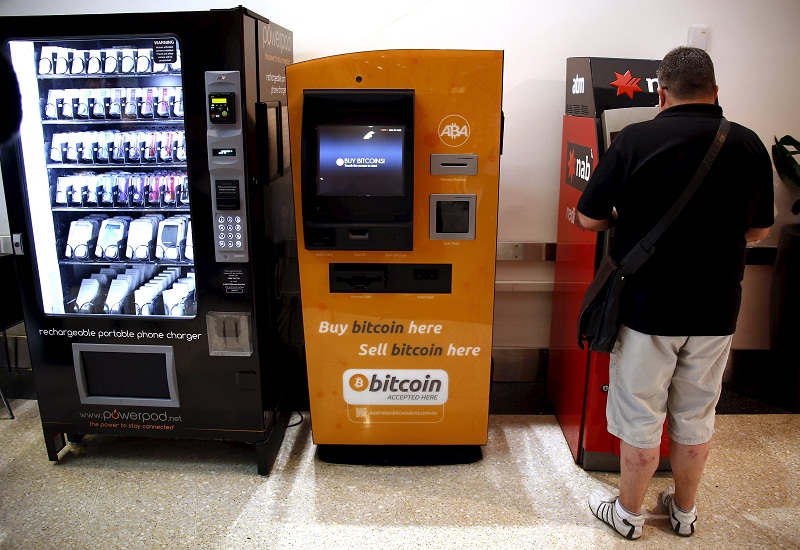 A customer of an Australian bank withdraws money from an Automatic Teller Machine (ATM) next to a Bitcoin ATM at a shopping mall in central Sydney, Australia, in this picture released on October 4, 2015. u00e2u20acu201d Reuters pic